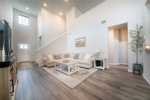 a living room with furniture and a wooden floor
