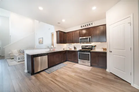 a kitchen with stainless steel appliances kitchen island granite countertop a refrigerator and a stove top oven