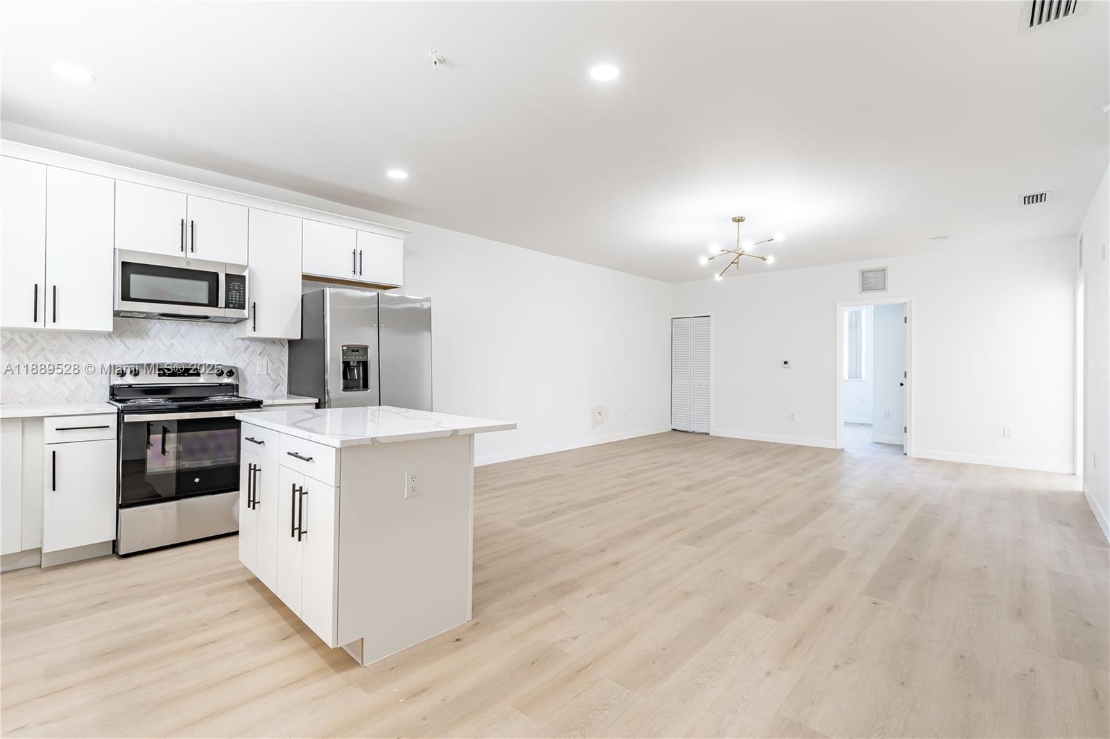 2575 Southwest 64th Avenue, Unit 7 Miramar, FL 33023 - Photo 4 of 13 a kitchen with kitchen island a sink stainless steel appliances and cabinets