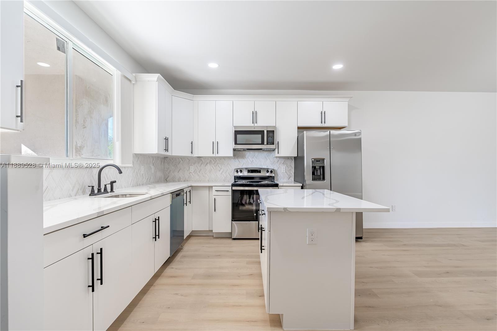 2575 Southwest 64th Avenue, Unit 7 Miramar, FL 33023 - Photo 5 of 13 a kitchen with kitchen island a sink stove and refrigerator