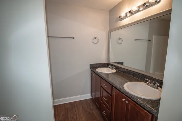 a bathroom with a granite countertop sink and a mirror