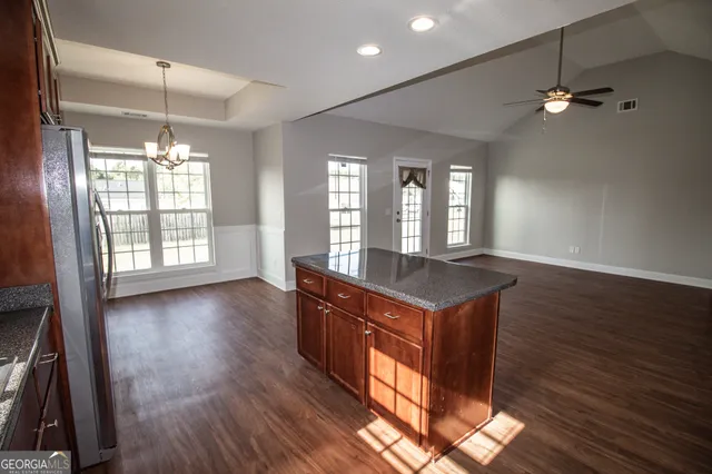 an open kitchen with wooden floor and large window