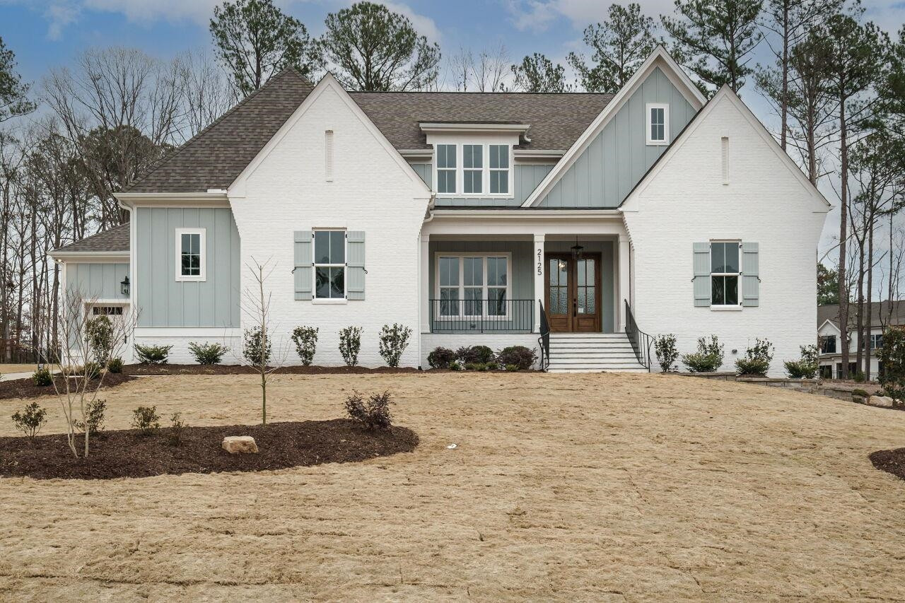 a view of a white house with a yard and large tree