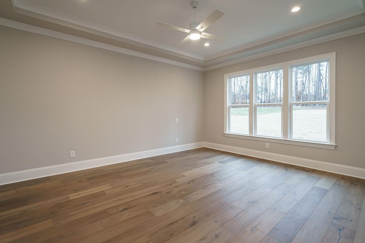2125 Gardenbrook Drive Raleigh, NC 27606 - Photo 17 of 35 a view of an empty room with wooden floor and a window