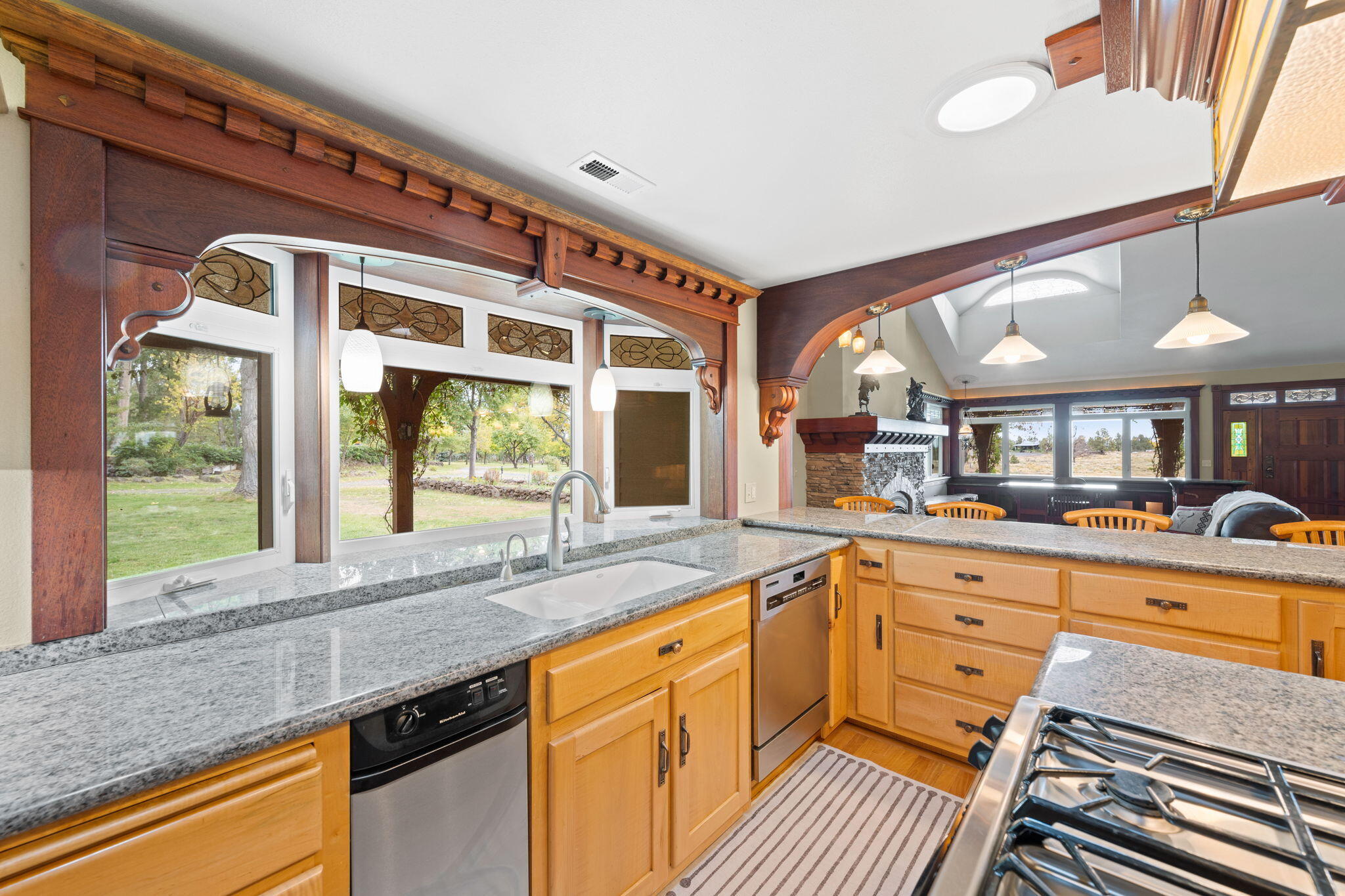 21925 Bear Creek Road Bend, OR 97702 - Photo 30 of 104 Specialty granite countertops, high end appliances and solid wood finishes in the open kitchen. The large bay window opens to the front yard and waterfall cascading from the upper pond