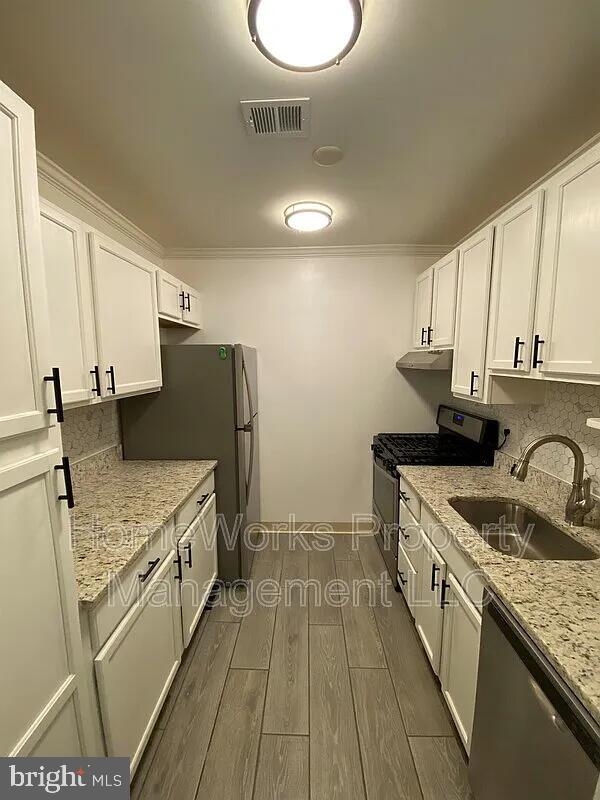 10547 Twin Rivers Road, Unit F2 Columbia, MD 21044 - Photo 1 of 2 a kitchen with a sink stove and refrigerator