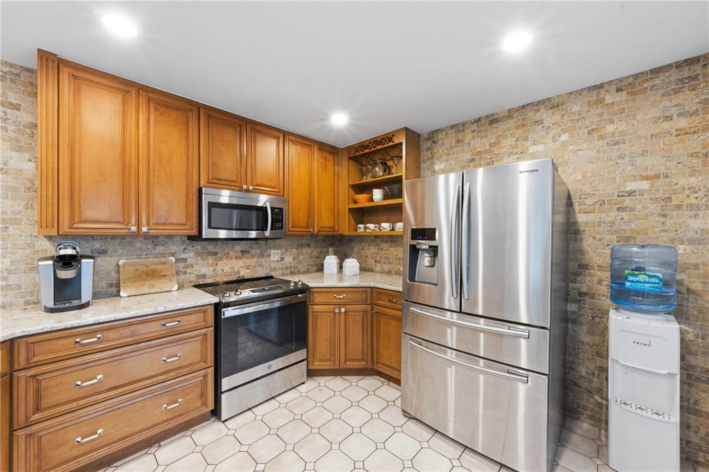 417 Poinsettia Road Anna Maria, FL 34216 - Photo 13 of 34 a kitchen with stainless steel appliances granite countertop a refrigerator stove and microwave
