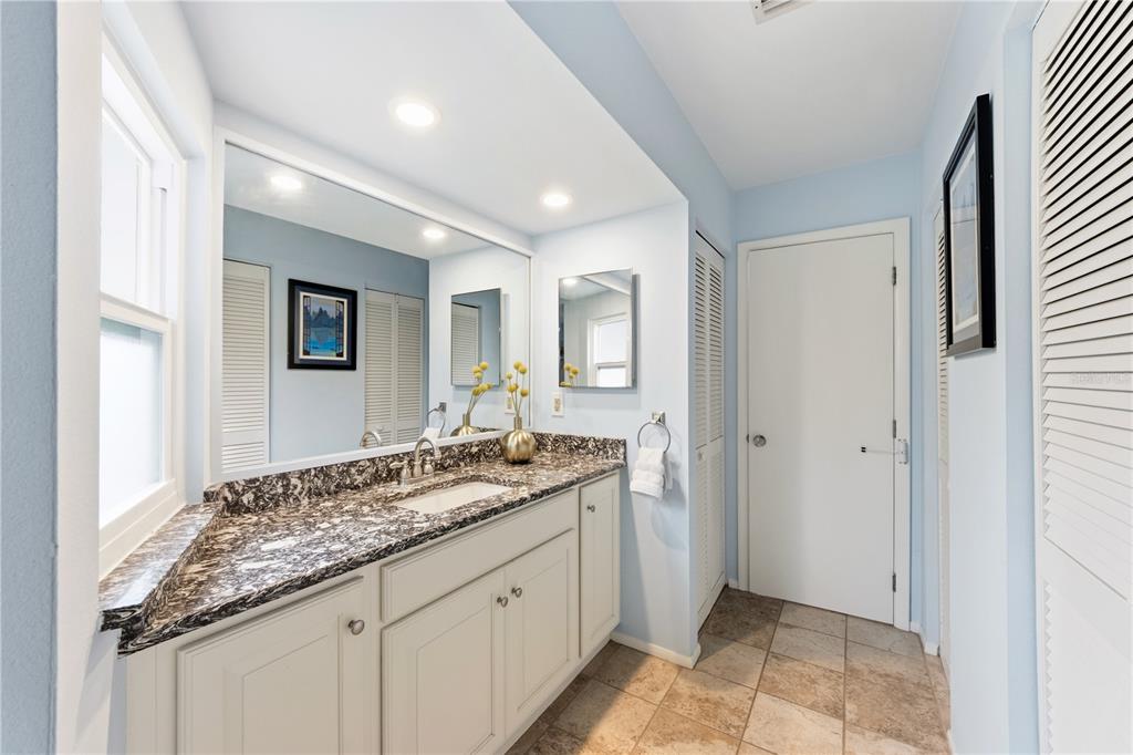417 Poinsettia Road Anna Maria, FL 34216 - Photo 20 of 34 a spacious bathroom with a granite countertop sink and a mirror