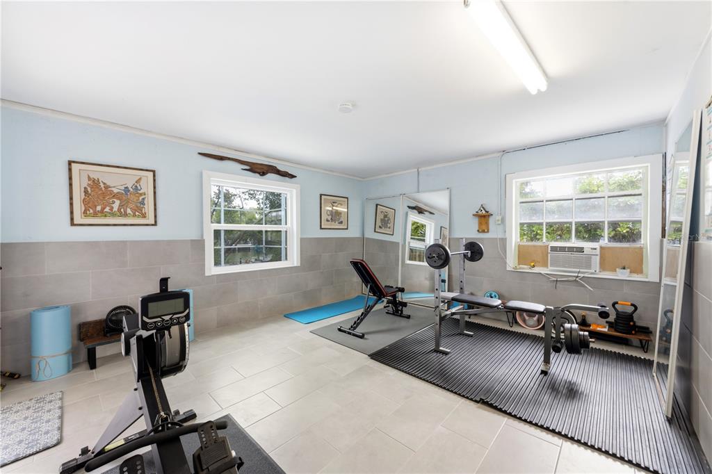 417 Poinsettia Road Anna Maria, FL 34216 - Photo 21 of 34 a living room with furniture a window and gym equipment