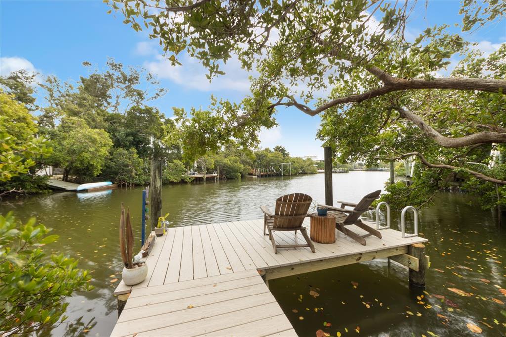 417 Poinsettia Road Anna Maria, FL 34216 - Photo 27 of 34 a view of a lake with couches chairs and large trees