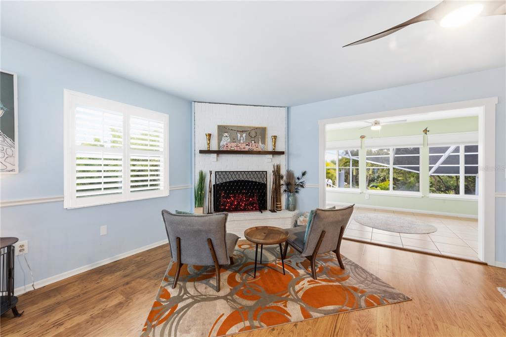 417 Poinsettia Road Anna Maria, FL 34216 - Photo 10 of 34 a dining room with furniture a fireplace and wooden floor