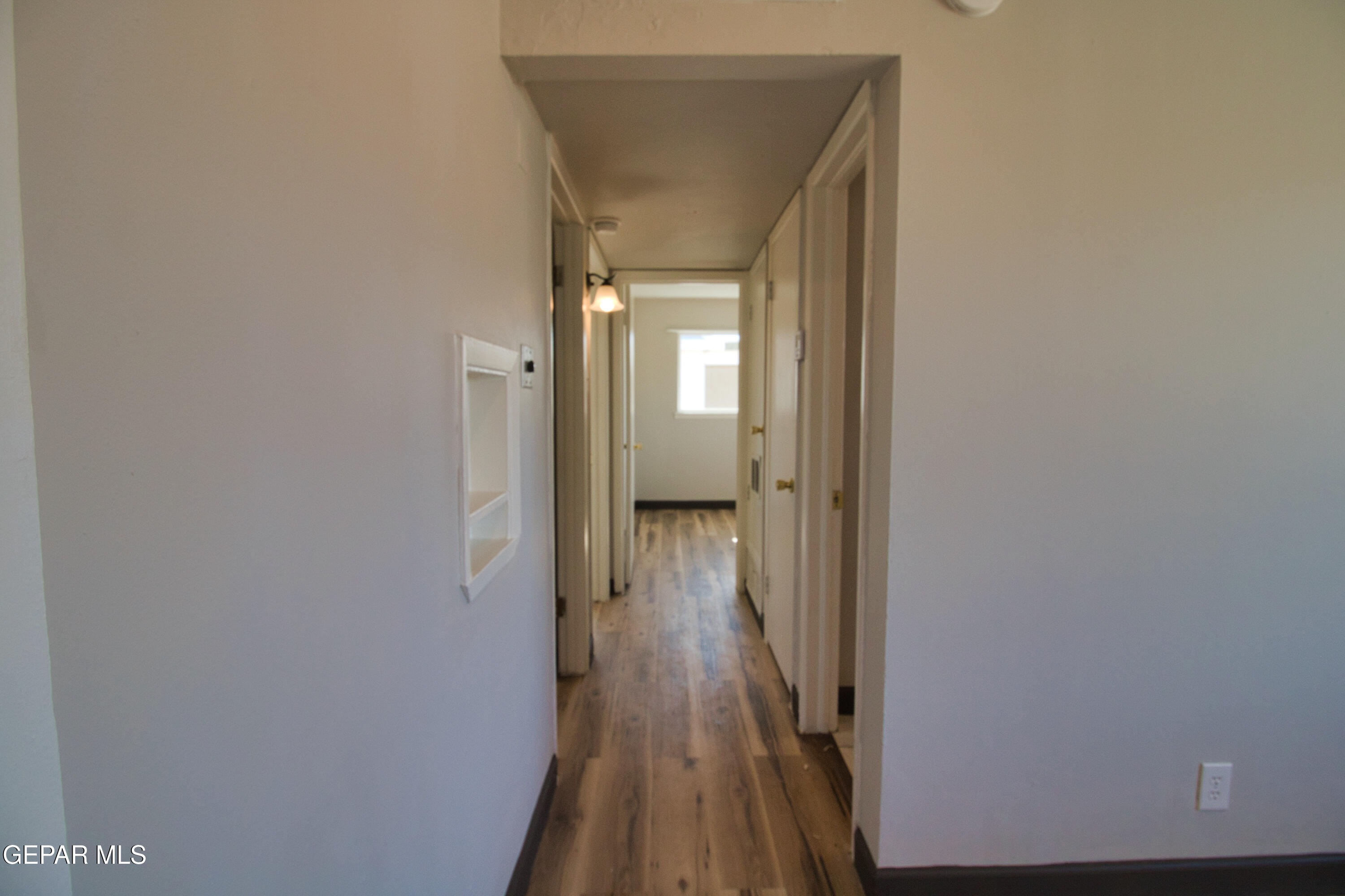 9104 Raleigh Drive El Paso, TX 79924 - Photo 11 of 20 a view of a hallway with wooden floor and a bathroom