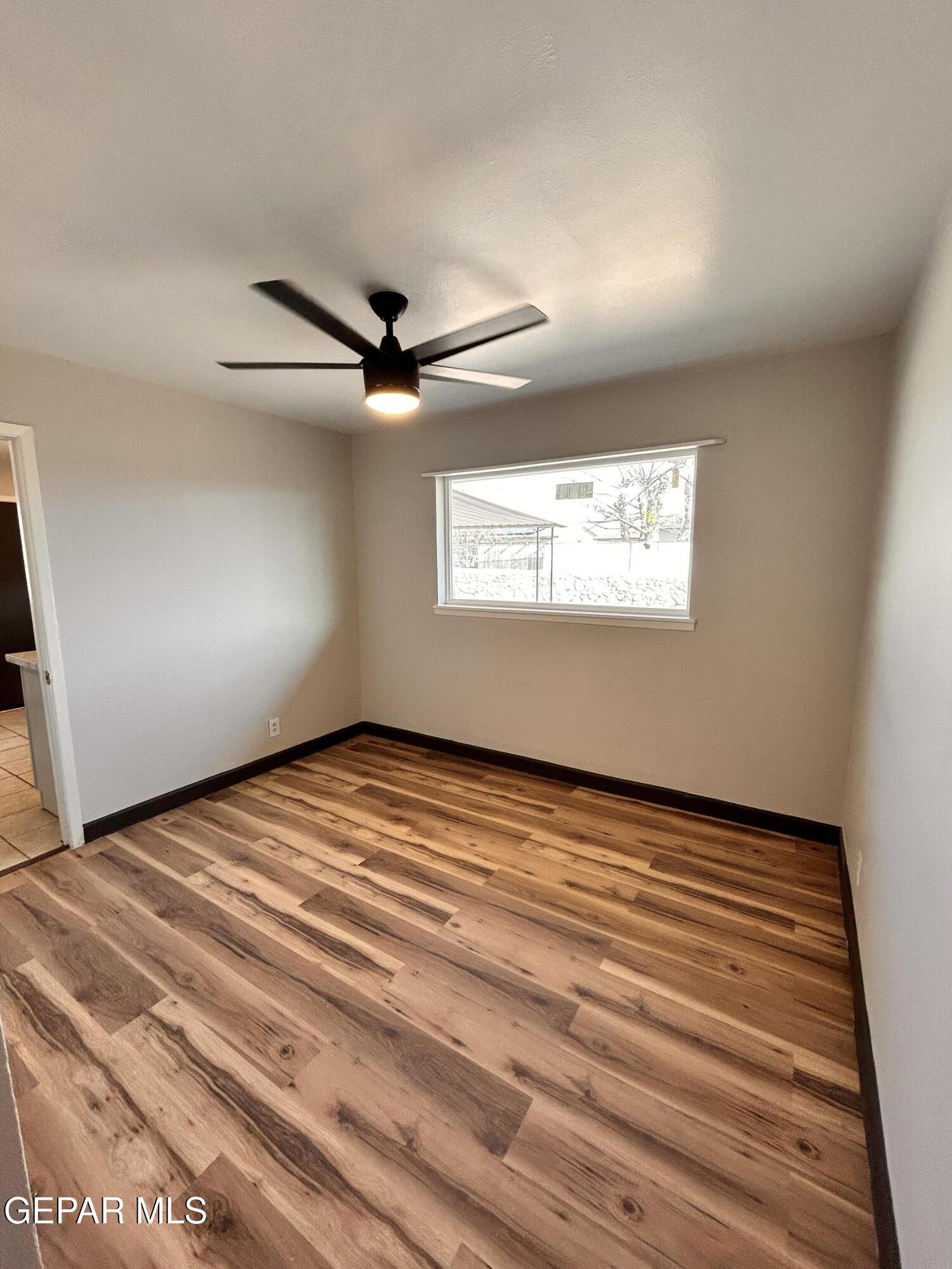 9104 Raleigh Drive El Paso, TX 79924 - Photo 9 of 20 a view of an empty room with a window and wooden floor