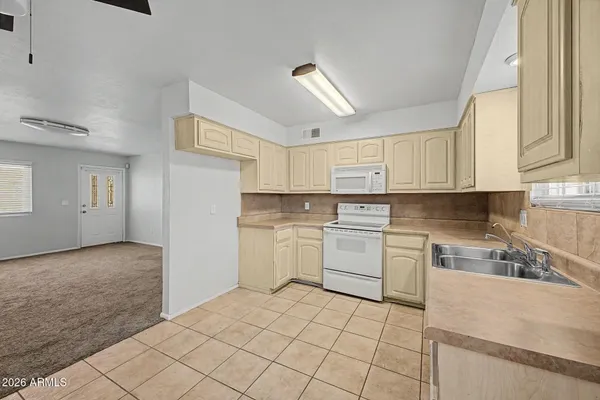 a kitchen with white cabinets appliances and a sink