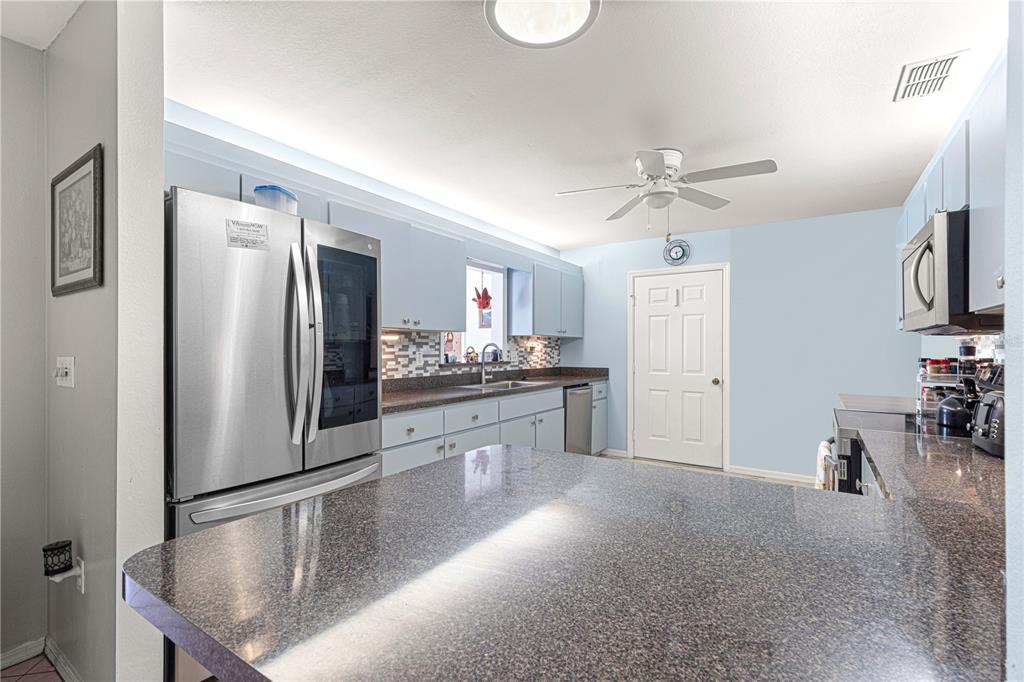 8475 Southeast 137th Loop Summerfield, FL 34491 - Photo 16 of 75 a kitchen with stainless steel appliances granite countertop a refrigerator a stove and a sink with cabinets