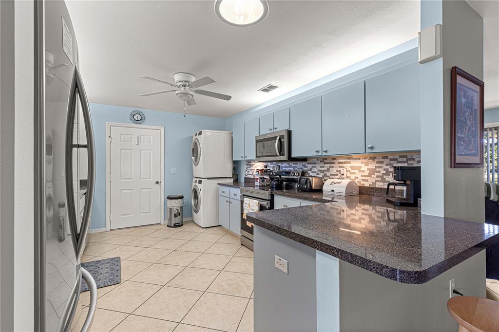 8475 Southeast 137th Loop Summerfield, FL 34491 - Photo 21 of 75 a kitchen with kitchen island granite countertop a sink appliances cabinets and counter space