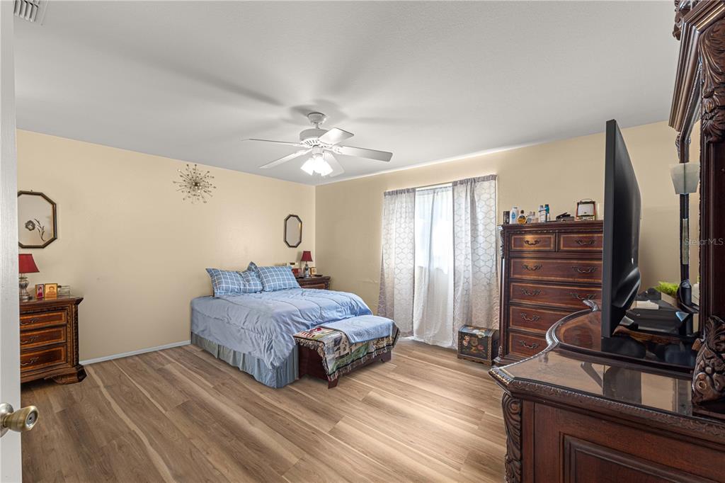 8475 Southeast 137th Loop Summerfield, FL 34491 - Photo 26 of 75 a bedroom with a bed and a flat tv screen on the dresser