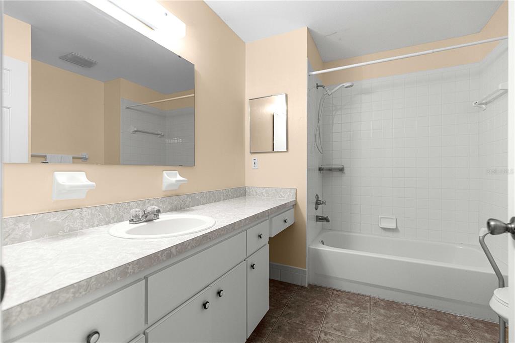 8475 Southeast 137th Loop Summerfield, FL 34491 - Photo 32 of 75 a bathroom with a tub shower sink vanity granite and a sink