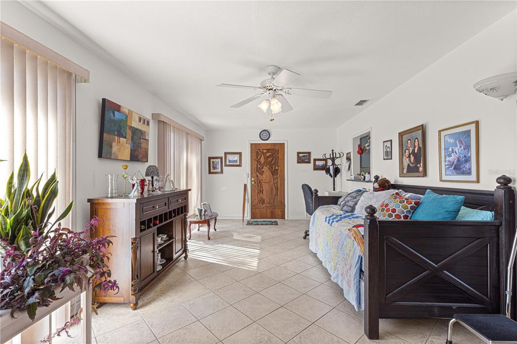 8475 Southeast 137th Loop Summerfield, FL 34491 - Photo 38 of 75 a bed room with furniture and a flat screen tv