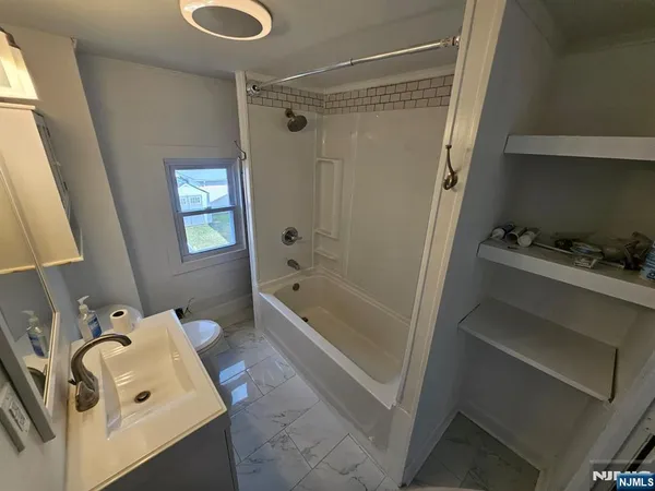 a bathroom with a tub sink and shower