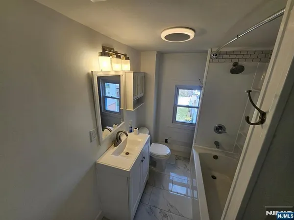 a bathroom with a sink a toilet and mirror