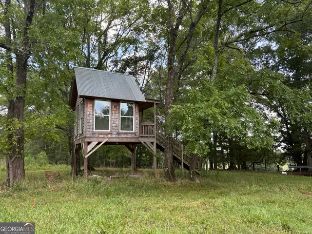 a view of an empty room with wooden floor and windows