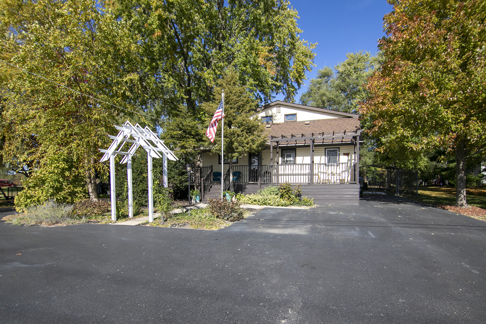 a view of a house with large trees and a small yard