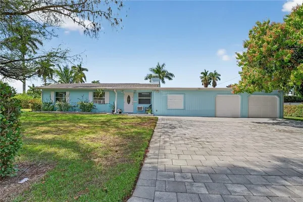a front view of a house with a yard and a garage