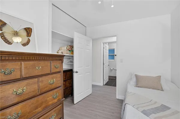 a view of a bedroom with wooden floor and cabinet