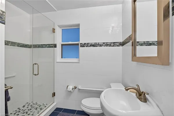 a bathroom with a sink a toilet and shower