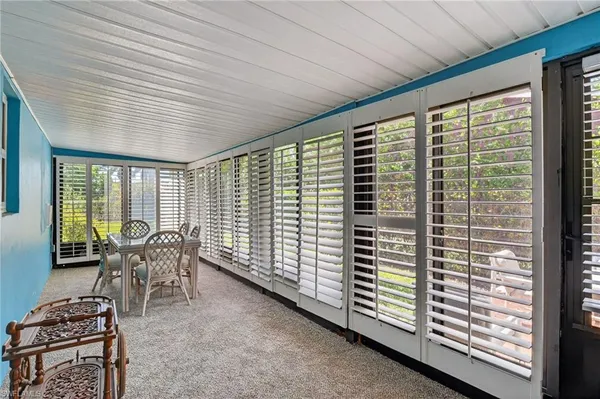 a dining room with furniture and floor to ceiling window