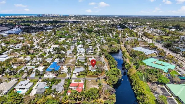 an aerial view of residential houses with outdoor space and trees