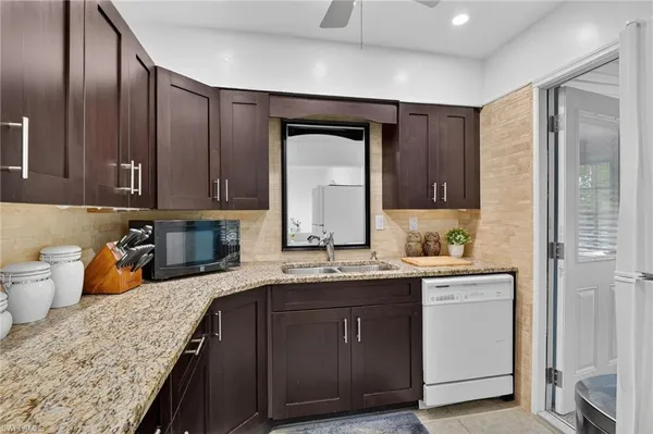 a kitchen with stainless steel appliances granite countertop a sink stove and cabinets