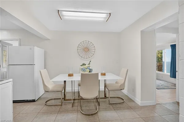 a view of a dining room with furniture and a refrigerator