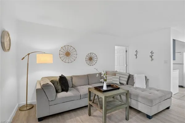 a living room with furniture a clock and a window