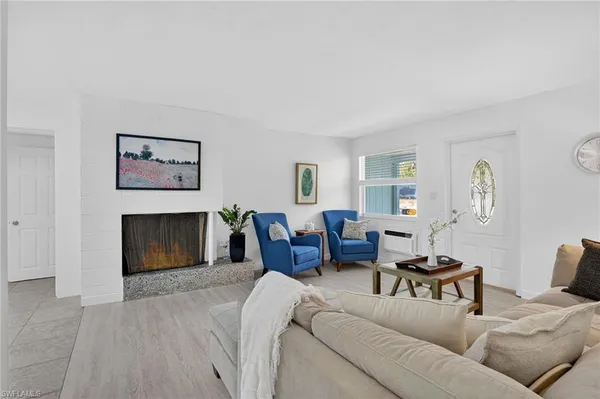 a living room with furniture a fireplace and a window