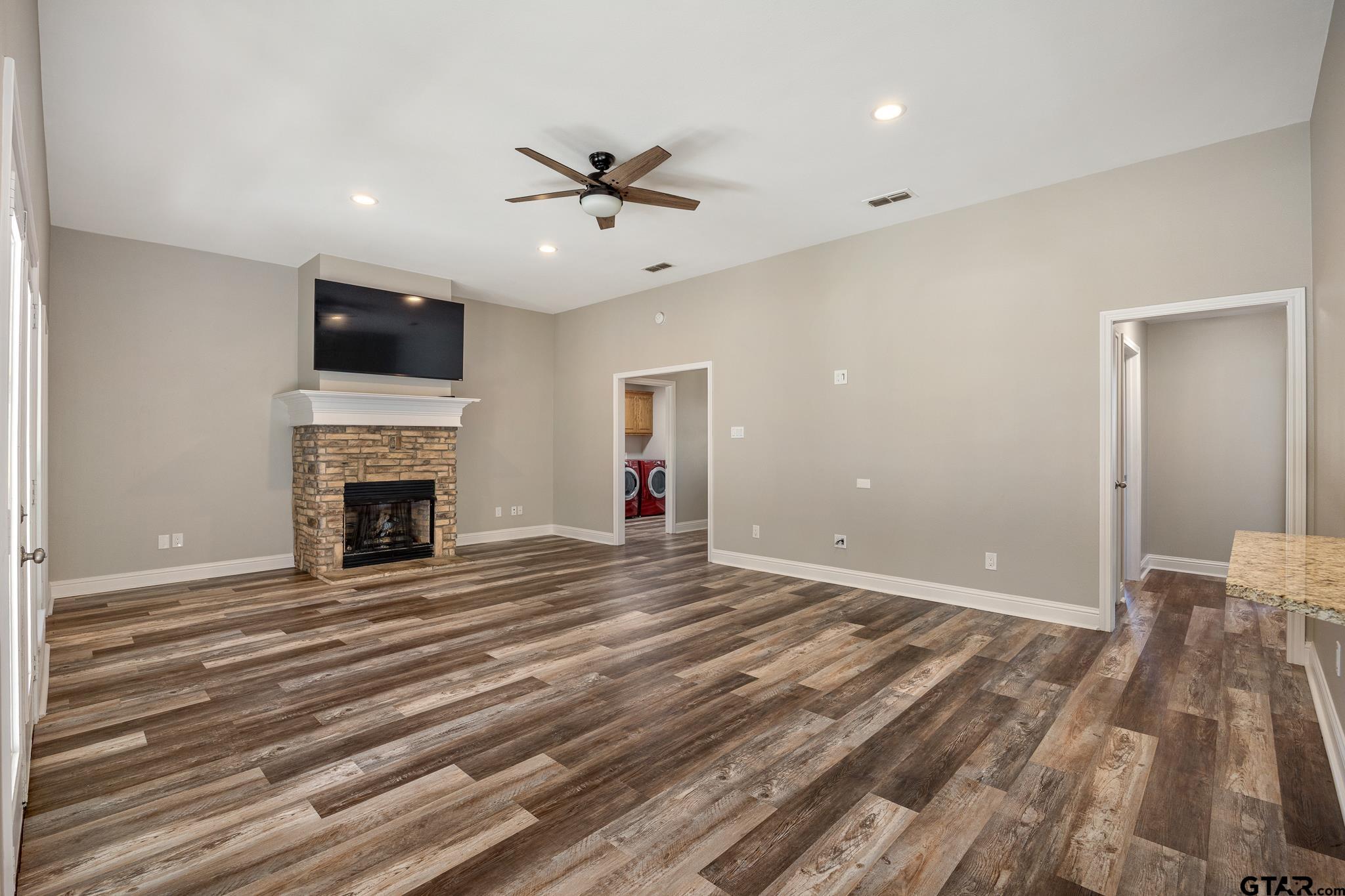 21237 Altuda Lane Flint, TX 75762 - Photo 11 of 48 a view of a livingroom with a fireplace a ceiling fan and wooden floor
