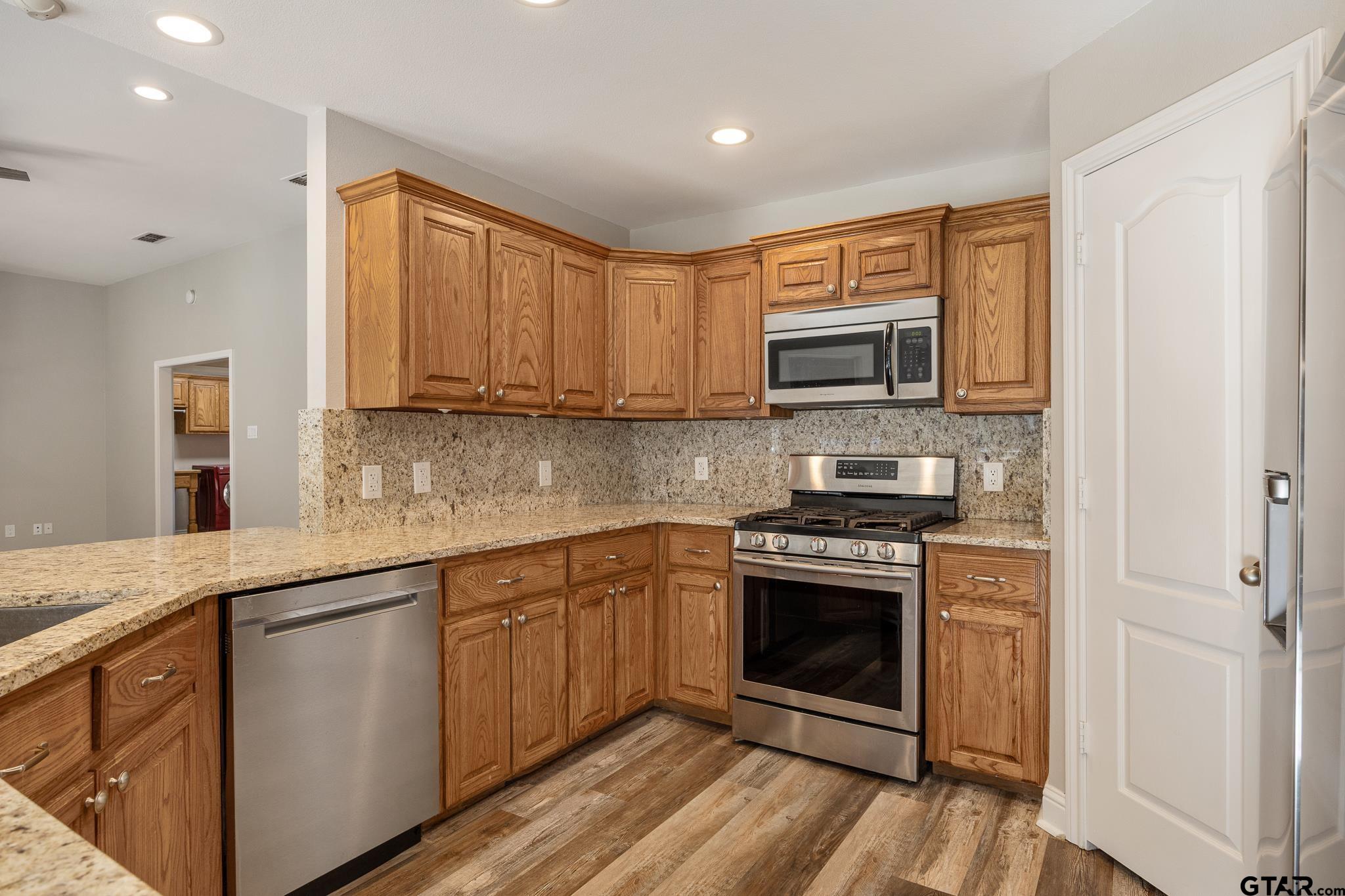 21237 Altuda Lane Flint, TX 75762 - Photo 15 of 48 a kitchen with stainless steel appliances granite countertop a stove microwave and sink