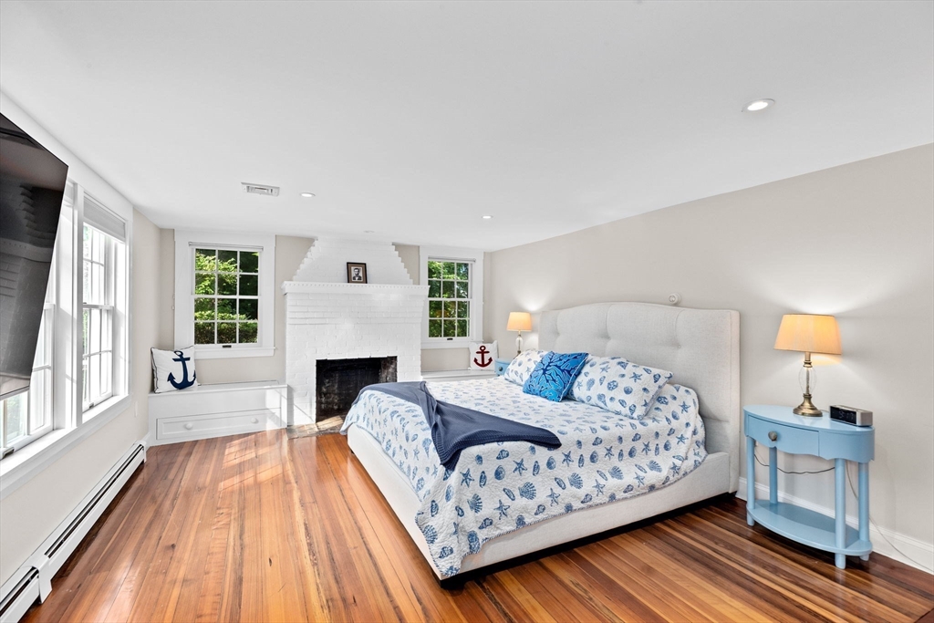 35 Ely Avenue Scituate, MA 02066 - Photo 21 of 33 a bedroom with a large bed and a fireplace