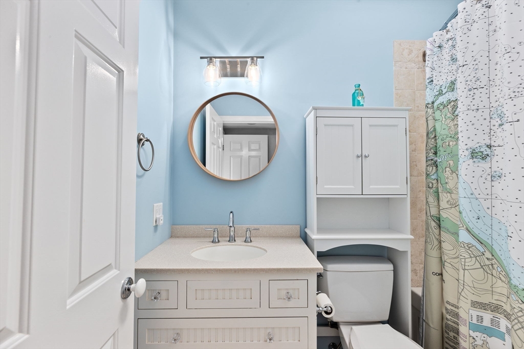 35 Ely Avenue Scituate, MA 02066 - Photo 23 of 33 a bathroom with a sink a mirror a toilet and a window