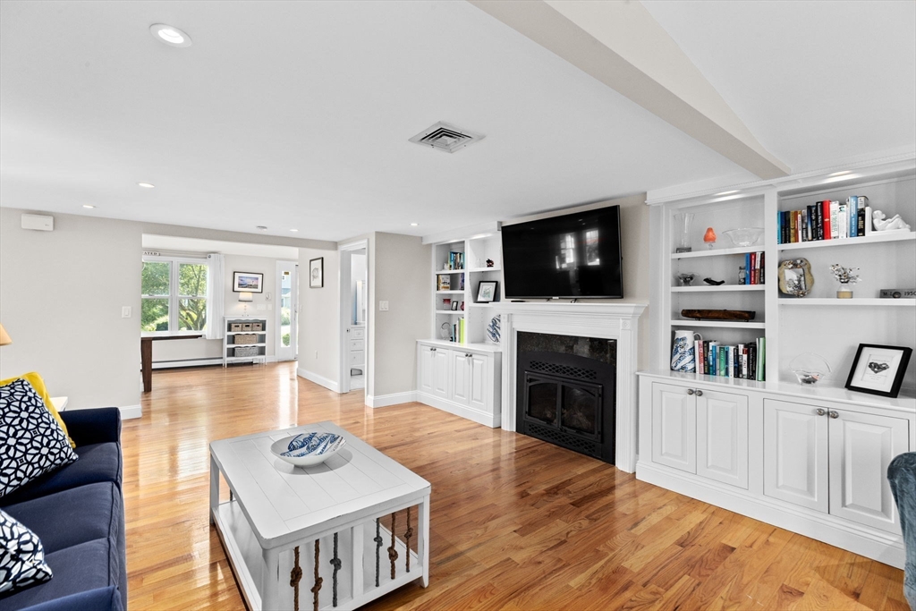 35 Ely Avenue Scituate, MA 02066 - Photo 8 of 33 a living room with furniture a flat screen tv and a fireplace