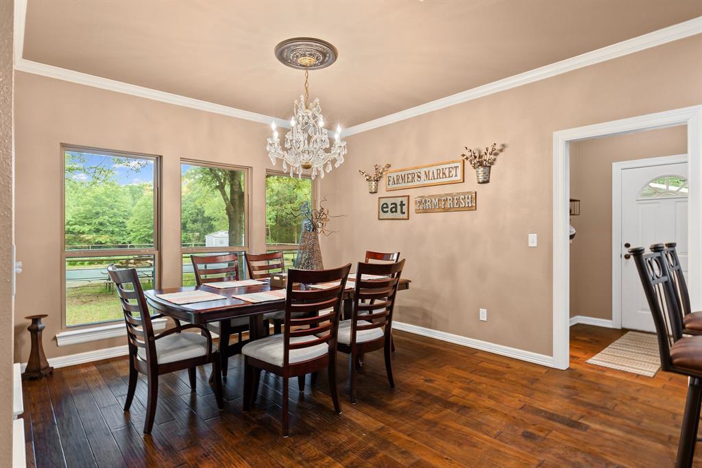 690 County Road Paris, TX 75462 - Photo 16 of 40 a view of a dining room with furniture wooden floor and chandelier