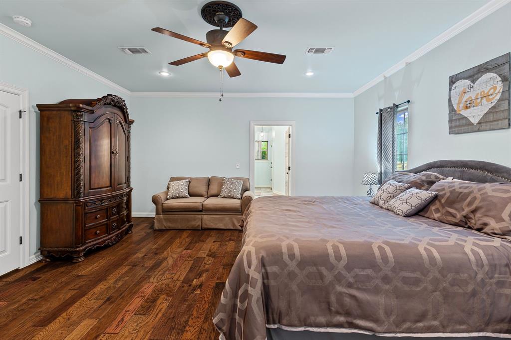 690 County Road Paris, TX 75462 - Photo 18 of 40 a bedroom with a bed a dresser and a chandelier