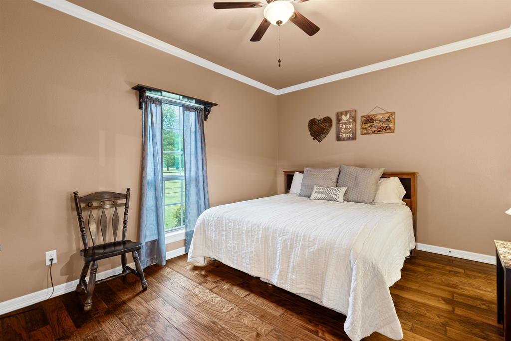 690 County Road Paris, TX 75462 - Photo 21 of 40 a bedroom with a bed and a chandelier