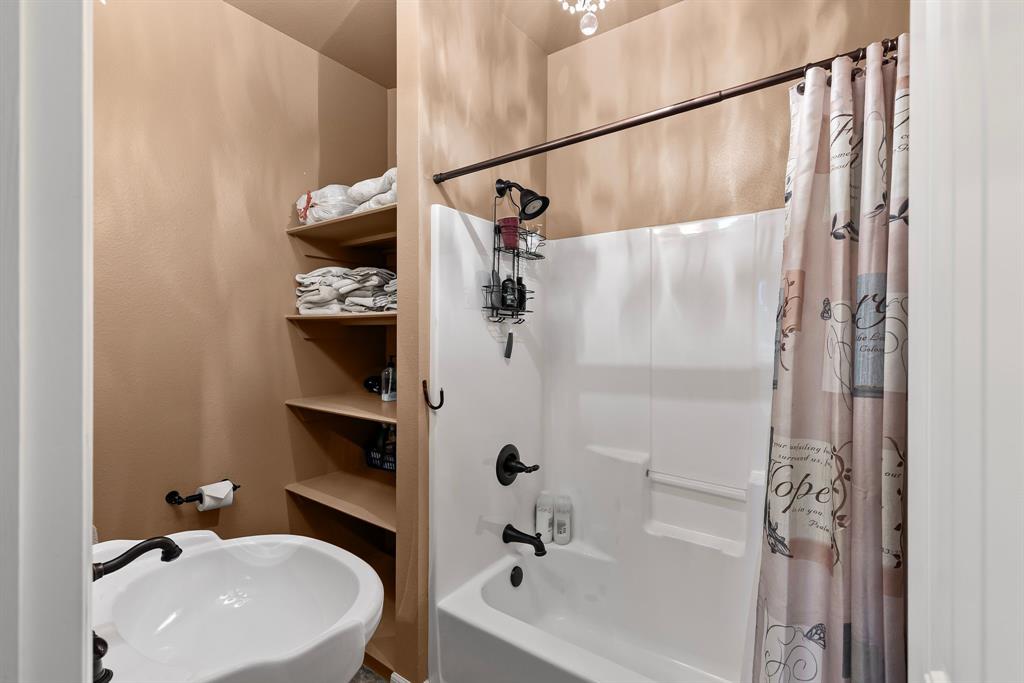 690 County Road Paris, TX 75462 - Photo 23 of 40 a bathroom with a white tub a sink and a shower