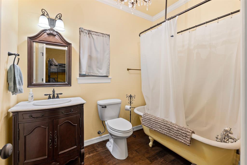 690 County Road Paris, TX 75462 - Photo 25 of 40 a bathroom with a toilet a sink and a mirror