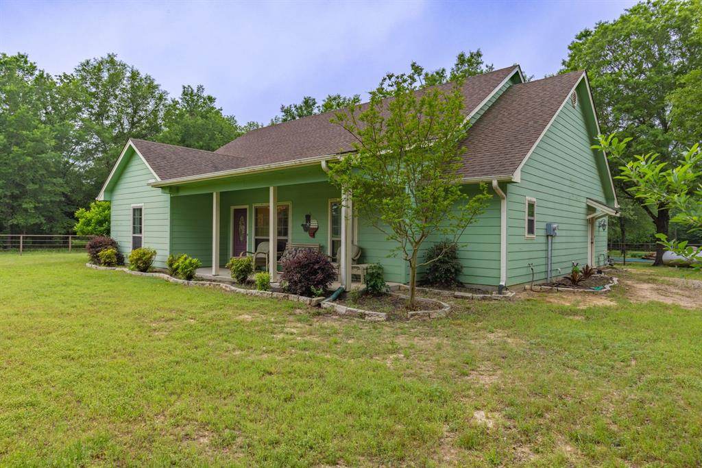 690 County Road Paris, TX 75462 - Photo 4 of 40 a front view of a house with a garden and yard