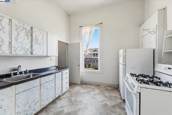 a kitchen with white cabinets and refrigerator