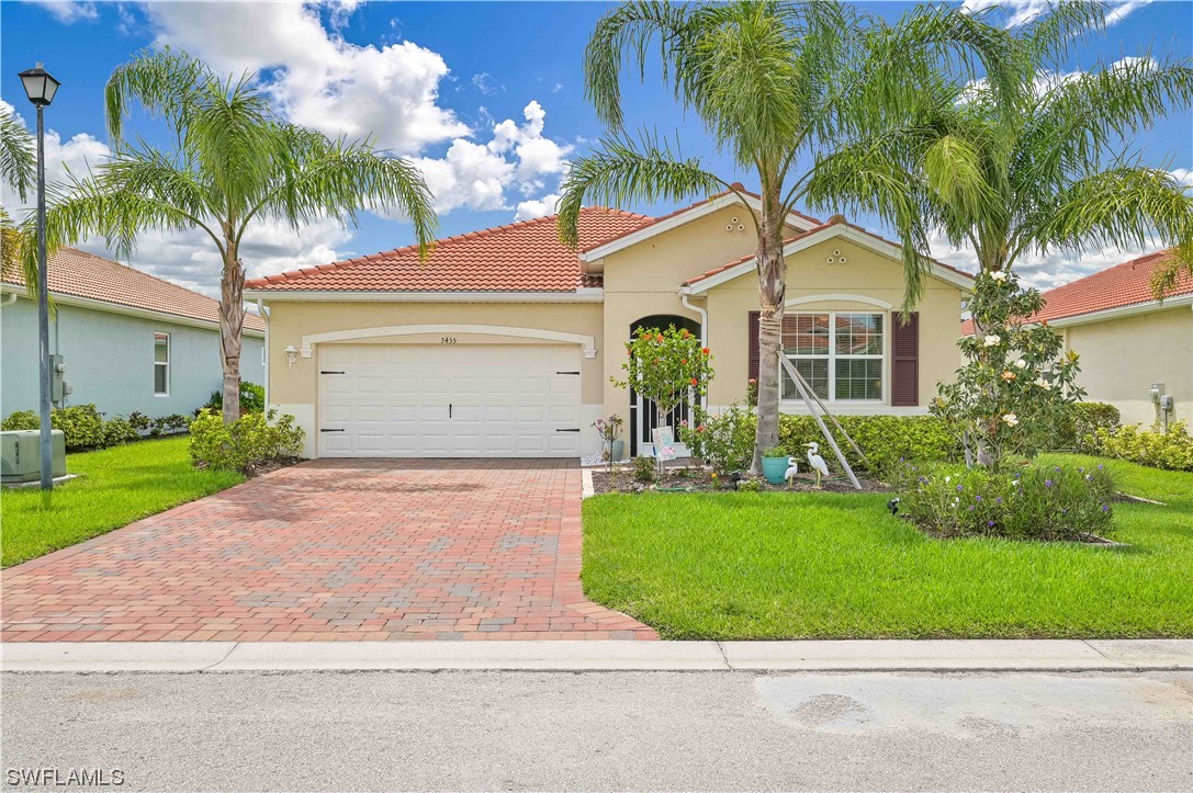 3435 Gold Flower Street Fort Myers, FL 33905 - Photo 1 of 39 a front view of a house with garden and palm trees
