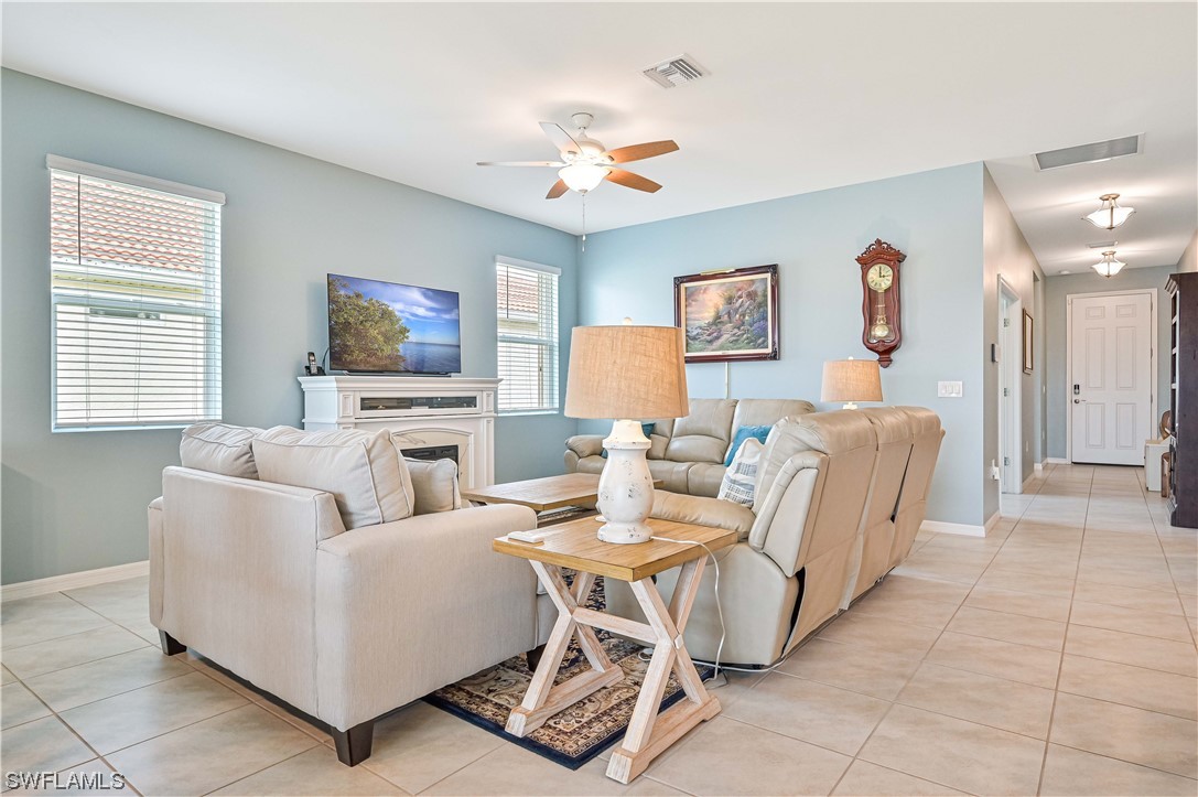 3435 Gold Flower Street Fort Myers, FL 33905 - Photo 13 of 39 a living room with furniture a flat screen tv and a fireplace